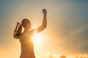 woman looking victoriously toward the sky. 